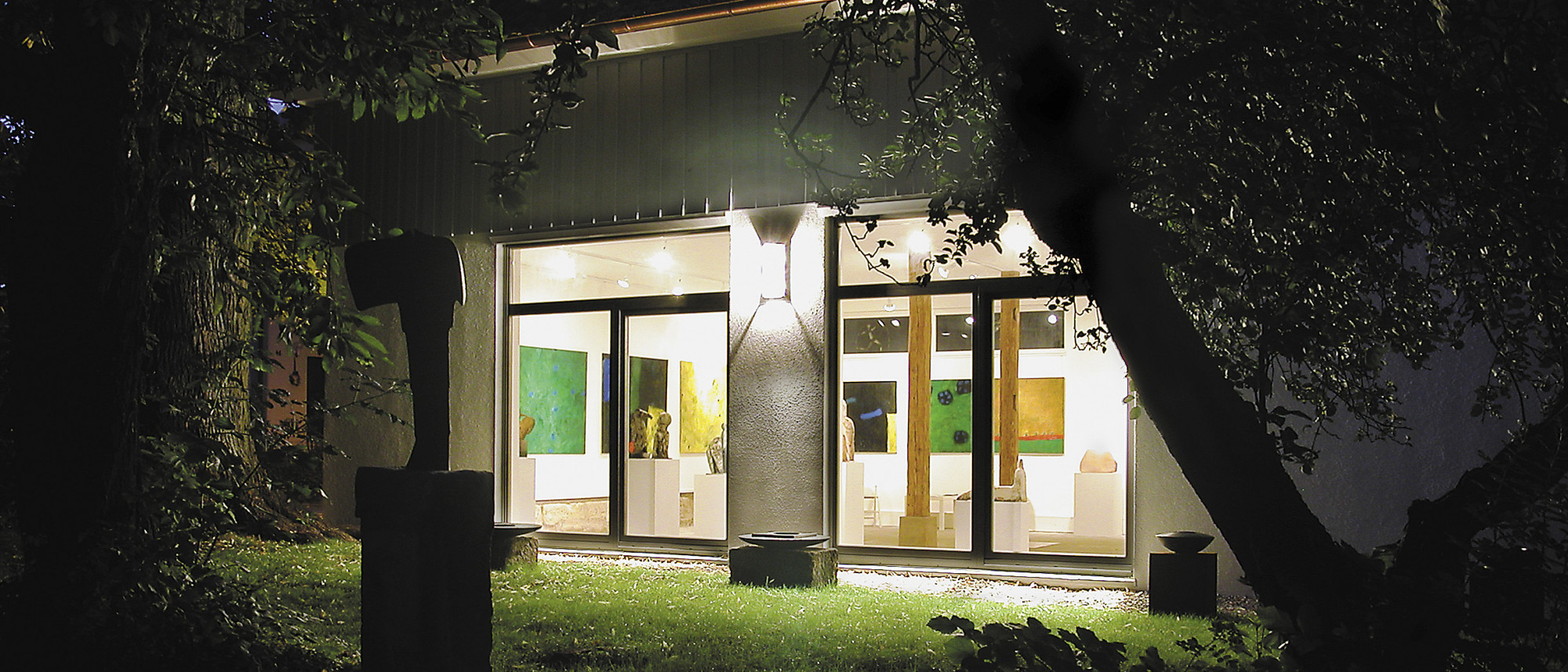 Blick von außen auf das beleuchtete Atelierhaus der Keramikwerkstatt Tittmann